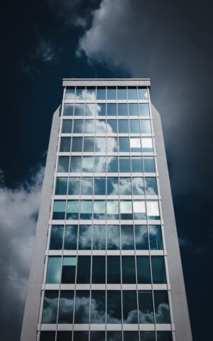 A tall building with lots of windows under a cloudy sky